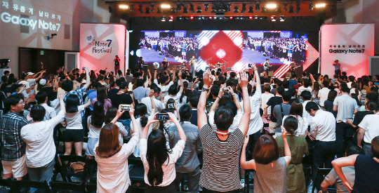 삼성전자 갤럭시노트7이 19일 공식 출시되면서 이동통신 3사가 불꽃 튀는 마케팅 경쟁에 돌입했다. 이통 3사는 저마다 갤럭시노트7 출시 행사를 여는가 하면 각종 사은품과 할인혜택을 제공하는 등 가입자 확보에 열을 올리고 있다. 지난 17일 서울 삼성전자 서초사옥에서 열린 '노트7 페스티벌'에서 초청된 사전 구매 예약자들이 밴드 '장기하와 얼굴들' 공연을 관람하고 있다. 삼성전자 제공